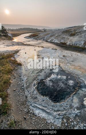 L'East Chinaman Spring bubbles et des steams près de la rivière Firehole dans le bassin Upper Geyser du parc national de Yellowstone dans le Wyoming, États-Unis. Banque D'Images