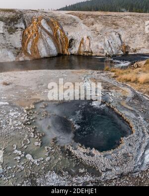 L'East Chinaman Spring bubbles et des steams près de la rivière Firehole dans le bassin Upper Geyser du parc national de Yellowstone dans le Wyoming, États-Unis. Banque D'Images