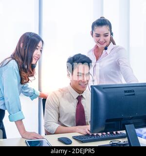 Groupe de jeunes hommes d'affaires en équipe avec micro-casque et ordinateur au bureau. Concept d'assistance aux entreprises. Banque D'Images