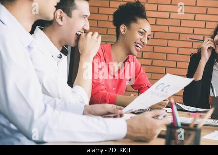 Les gens d'affaires du millénaire se réjouissant de rire et de s'amuser dans le réunion avec des collègues multiethniques Banque D'Images