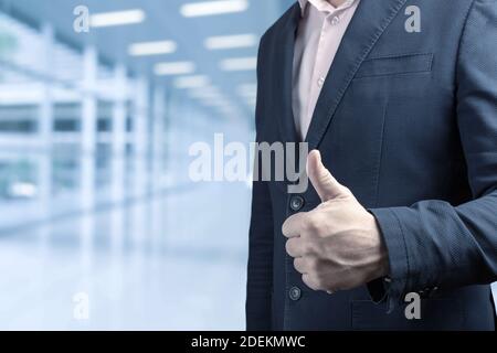 Un homme d'affaires qui donne des Thumbs. Main d'homme d'affaires donnant le pouce vers le haut geste dans une motivation d'affaires dans le fond de bureau. Montrant le pouce vers le haut de concept Banque D'Images