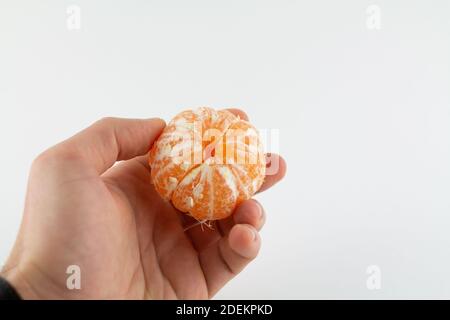 une mandarine pelée à la main sur fond blanc Banque D'Images