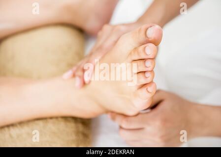 Massage traditionnel thaïlandais de réflexologie des pieds fourni par un thérapeute dans le salon de spa Banque D'Images