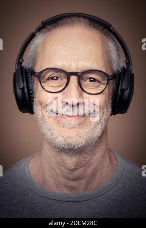 Prise de vue d'un homme adulte avec une barbe portant un casque stéréo et des lunettes. Banque D'Images