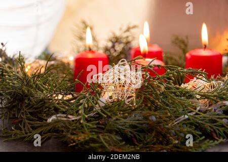 Couronne d'Avent ou de Noël avec quatre bougies de cire rouge et étoiles dorées.Couronne de l'Avent traditionnelle aux bougies rouges le quatrième dimanche de l'Avent. Banque D'Images