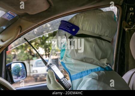 Mandalay, Myanmar. 24 novembre 2020. Un volontaire portant un équipement de protection utilise une radio réseau pour transporter des patients positifs Covid-19 de l'hôpital général Mandalay au centre positif Covid-19.Charitable Minkhaung Search and Rescue Team à Obo Ward, au nord de Mandalay est un organisme de bienfaisance qui transporte principalement des patients confirmés Covid-19. Tous les membres de cette organisation ont dû rester au bureau au lieu de rentrer à la maison parce que leurs parents et leurs environs ne pouvaient pas les accepter parce qu'ils portaient les patients confirmés Covid-19. Charitable Minkhaung se Banque D'Images