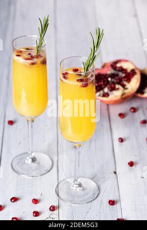 Queue de Mimosa avec jus d'orange et champagne. Nouvelle année ou fête d'anniversaire. Grenade et romarin Banque D'Images