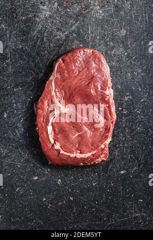 Émincé de steak de ribeye cru sur une table de cuisine noire. Vue de dessus.