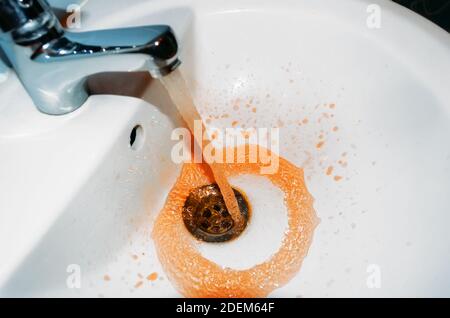 Rouille s'écoulant du robinet dans la salle de bains. Le concept du problème est l'eau sale Banque D'Images