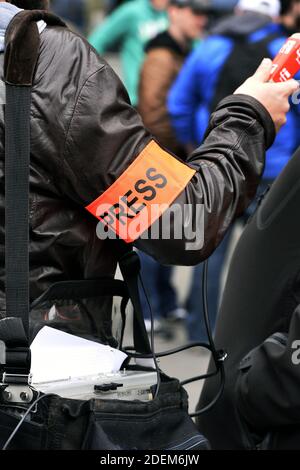 Journaliste reporter portant un bracelet de presse dans une interview lors d'une manifestation à Paris - France Banque D'Images