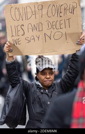 Manifestation anti-verrouillage, Londres, 28 novembre 2020. Une femme noire marchant et tenant un écriteau de protestation au-dessus de sa tête. Banque D'Images