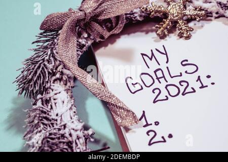 Concept des objectifs. Liste des objectifs de la nouvelle année 2021. Cahier et décorations de noël isolés sur fond bleu. Inscription objectifs 2021 dans cahier, concept Banque D'Images