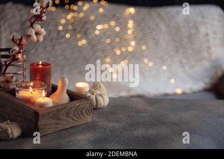 Bougies dans la boîte en bois isolée sur fond gris blanc. Guirlande lumineuse. Le concept de l'atmosphère et du confort à la maison, vacances, date romantique, hiver, confort à la maison, intérieur, Noël ou nouvel an. Banque D'Images