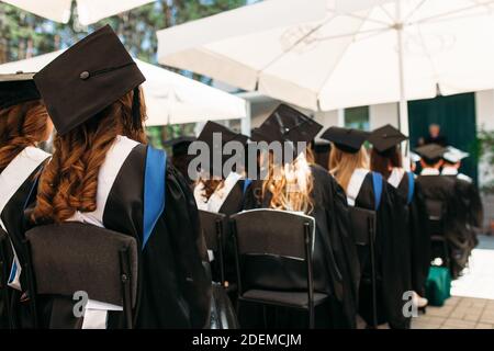 Les diplômés qui réussissent dans des robes universitaires, à l'obtention du diplôme, assis sous la forme de diplômés, peuvent être utilisés pour la publicité, Banque D'Images