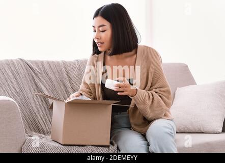 Femme asiatique déballage colis avec coffret beauté Banque D'Images