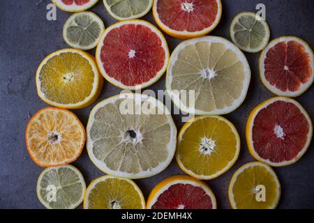 Tranches d'orange rouge sur une table. Gros plan sur la texture des fruits. Arrière-plan gris foncé avec espace de copie. Banque D'Images