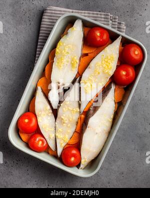 Steaks de flétan frais dans un plat de cuisson avec tomates et patates douces. Copier l'espace. Plat à poisson. Banque D'Images