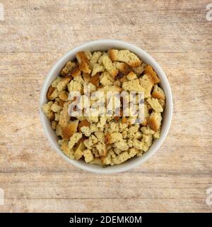 Vue de dessus d'un bol d'ingrédients non cuits pour la cuisson sur une vieille planche à découper en bois. Banque D'Images