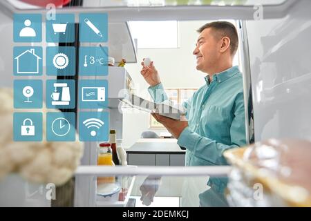 L'homme de prendre les oeufs de réfrigérateur à la cuisine Banque D'Images