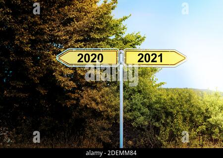 Panneaux de signalisation jaunes dans des directions opposées avec le texte 2020 et 2021, pointant vers un avenir plus brillant, concept de nouvel an, espace de copie Banque D'Images