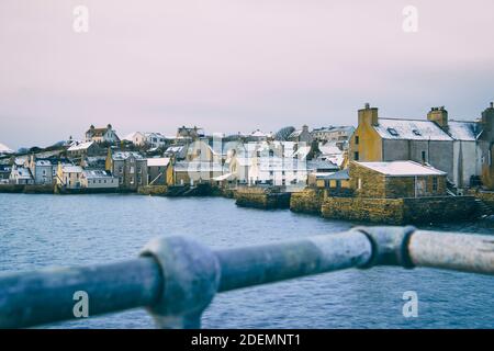 Vue sur le front de mer de Stromness sur les îles Orcades en hiver avec rail flou en premier plan Banque D'Images