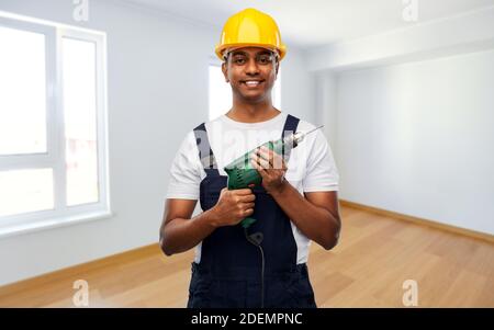 joyeux constructeur indien en casque avec perceuse électrique Banque D'Images