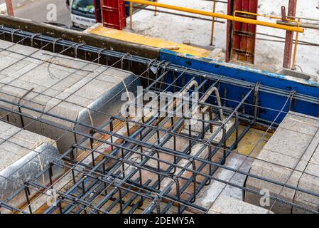 Chantier de construction avec coffrages en acier et barres de renfort pour piliers prêt pour le coulage du béton Banque D'Images