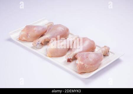 Bâtonnets de poulet crus disposés sur une table blanche arrière-plan blanc Banque D'Images