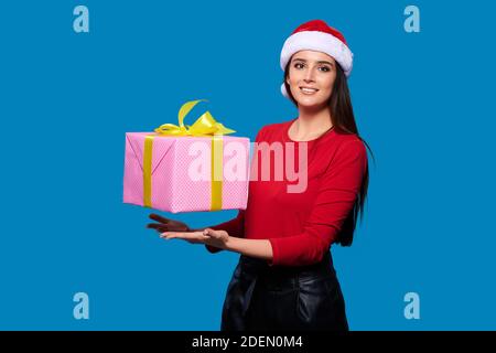 Femme souriante dans le chapeau du Père Noël avec boîte cadeau sur bleu isoler l'arrière-plan Banque D'Images