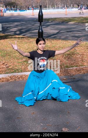 Une danseuse paraguayenne répète à Flushing Meadows Corona Park tout en équilibrant 2 bouteilles de vin sur sa tête. Banque D'Images