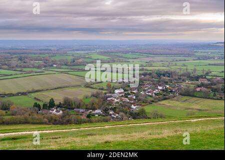 Vue vers le nord sur le village de Fulking et les terres agricoles dans une lumière douce et hivernante de South Downs Way, West Sussex, Angleterre. Banque D'Images