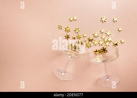 Verres à champagne avec paillettes dorées sur fond rose. Flat Lay, vue de dessus, concept de noël tendance. Banque D'Images