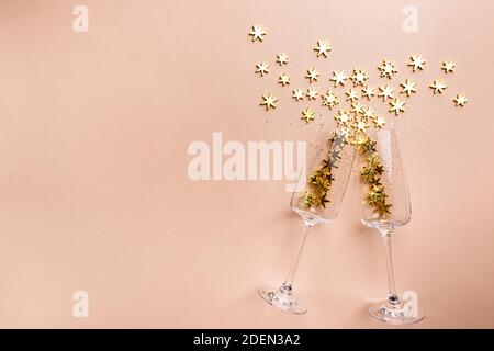 Verres à champagne avec paillettes dorées sur fond rose. Flat Lay, vue de dessus, concept de noël tendance. Banque D'Images