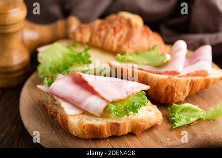 Croissant avec jambon, fromage et salade de laitue. Sandwich ouvert croissant Banque D'Images