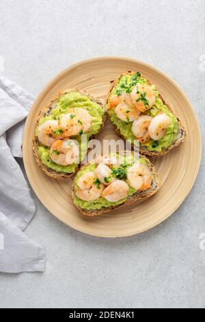 Crevettes avocat bruschettas sur une plaque en bois. Vue de dessus Banque D'Images