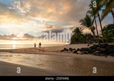 Un couple marchant sur la plage au coucher du soleil, plage de Flic en flac, île maurice Banque D'Images