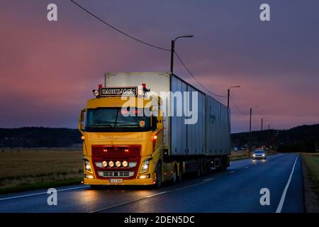 Magnifiquement personnalisé, Volvo jaune FH16 de TransHartikainen Ky tire une remorque au début de l'hiver crépuscule sur l'autoroute 52. Salo, Finlande. 26 novembre 2020. Banque D'Images