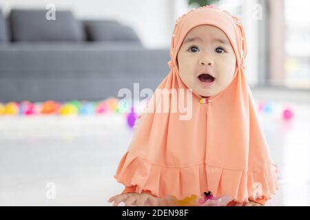 Bébé musulman joue avec des jouets colorés dans le salon Banque D'Images