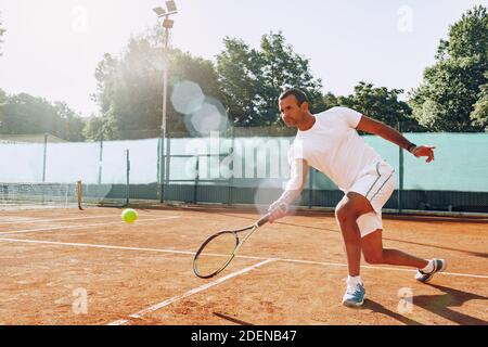 FIT man joue au tennis sur le terrain Banque D'Images