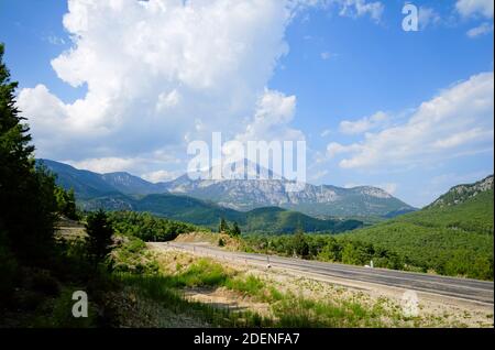 Route dans les montagnes. Pic de montagne appelé Tahtali ou Olympe lycienne sur un fond. Randonnée sur la voie lycienne dans les montagnes du Taurus en Turquie. Banque D'Images