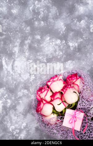 Bouquet de fleurs rose rouge blanc rose avec boîte-cadeau sur table en pierre. Le concept d'une carte postale pour la Fête des Mères, le 8 mars, le saint Valentin, ou la naissance Banque D'Images