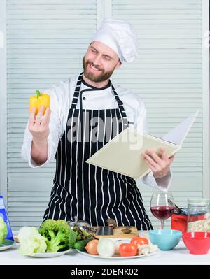 Chef barbu homme à la cuisson des aliments. Guy lire livre de recettes. Concept d'arts culinaires. Apprendre l'homme recette. Améliorer les compétences de cuisson. Guide de cuisson ultime pour les débutants. Livre des recettes de famille. Selon recette. Banque D'Images