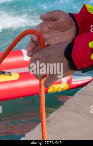 Un tir vertical d'un pompier près d'une corde une piscine sous la lumière du soleil Banque D'Images