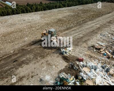 Vue du haut du drone de la décharge. Différents types de déchets. Le tracteur transporte les déchets. Pollution de l'environnement. Banque D'Images