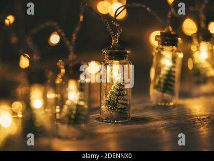 Décoration de Noël guirlande électrique avec petit arbre de Noël à l'intérieur de lumières aux tons chauds couvertes sur la table en bois. L'ambiance de Noël est très ouverte Banque D'Images