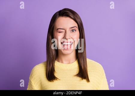 Photo portrait de jeune fille en forme de clin d'œil souriant isolé sur un arrière-plan violet de couleur vive Banque D'Images