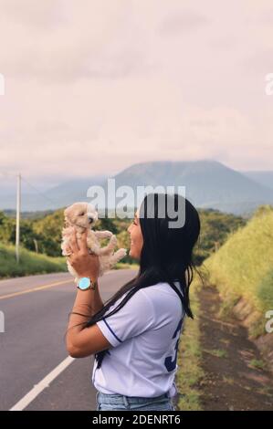 Une jeune femme tenant un adorable petit chiot en forme de coolé français Banque D'Images