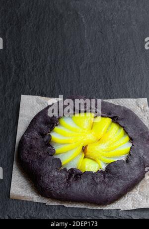 Tarte au chocolat avec poire pochée sur fond de pierre noire Banque D'Images