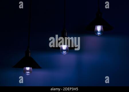 Trois lampes avec ampoules à incandescence vintage en lumière bleue Banque D'Images