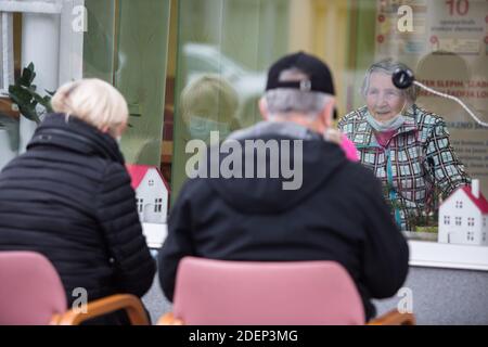 Skofja Loka, Slovénie. 1er décembre 2020. Une famille utilisant un système de communication bidirectionnelle installé sur une fenêtre lors de sa visite à un habitant âgé d'une maison de soins infirmiers.les maisons de soins infirmiers en Slovénie ont commencé à permettre des visites sans contact après deux mois de verrouillage strict dans le cadre de la deuxième vague d'épidémie de covid-19 en Slovénie. La situation du coronavirus en Slovénie est l'une des pires au monde en ce qui concerne les décès par habitant. Les maisons de retraite ont été les plus touchées dans la première vague, et sont de nouveau en train de prendre un grand coup. Credit: Luka Dakskobler/SOPA Images/ZUMA Wire/Alay Live News Banque D'Images